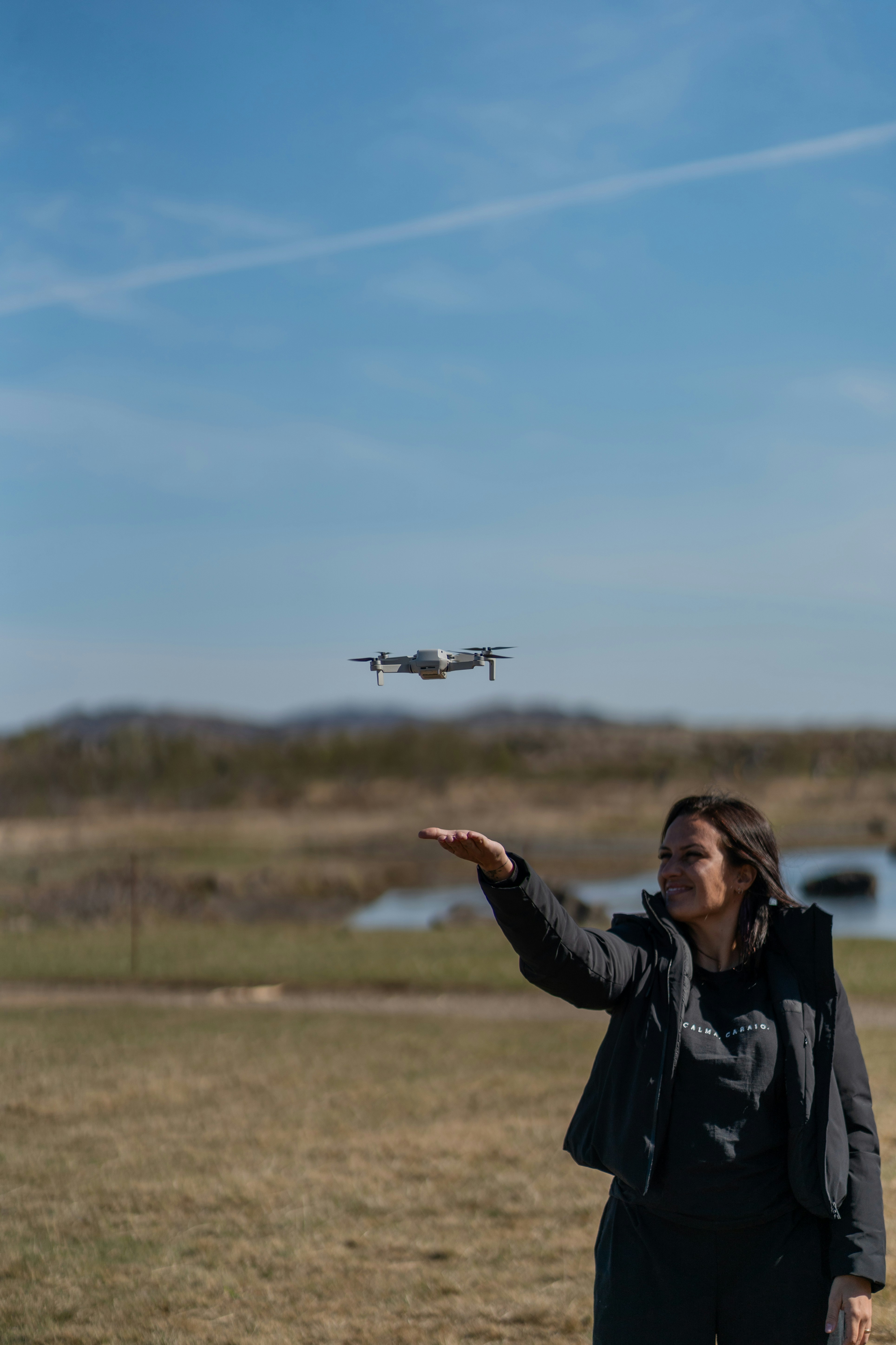 Young woman and drone in a field
